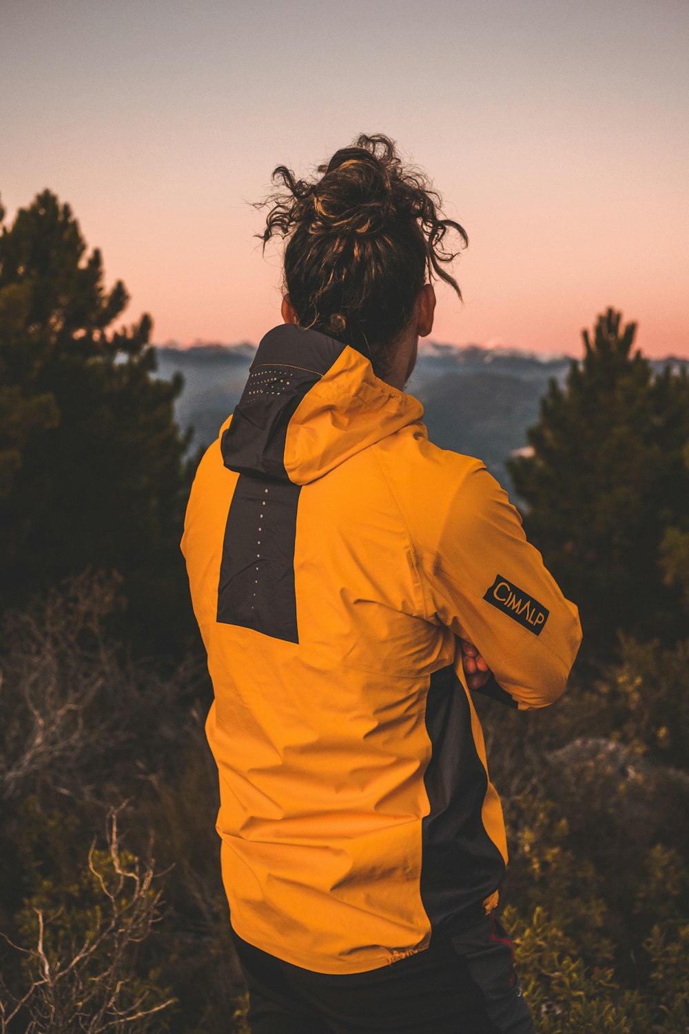 a man with dreadlocks standing on top of a mountain