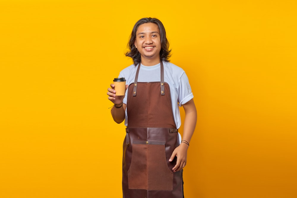 a man in an apron holding a cup of coffee