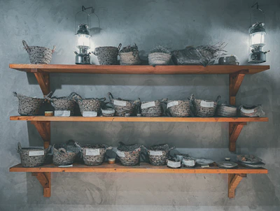 Warmly lit corner featuring handmade lanterns and woven baskets on wooden shelves.