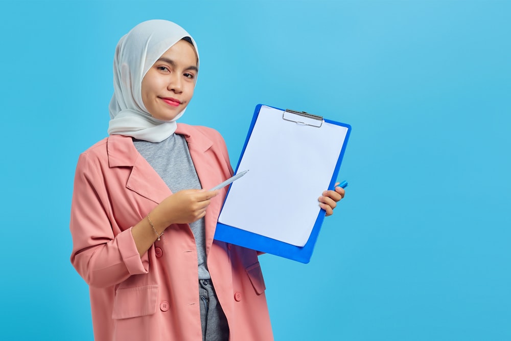 a woman in a hijab holding a clipboard