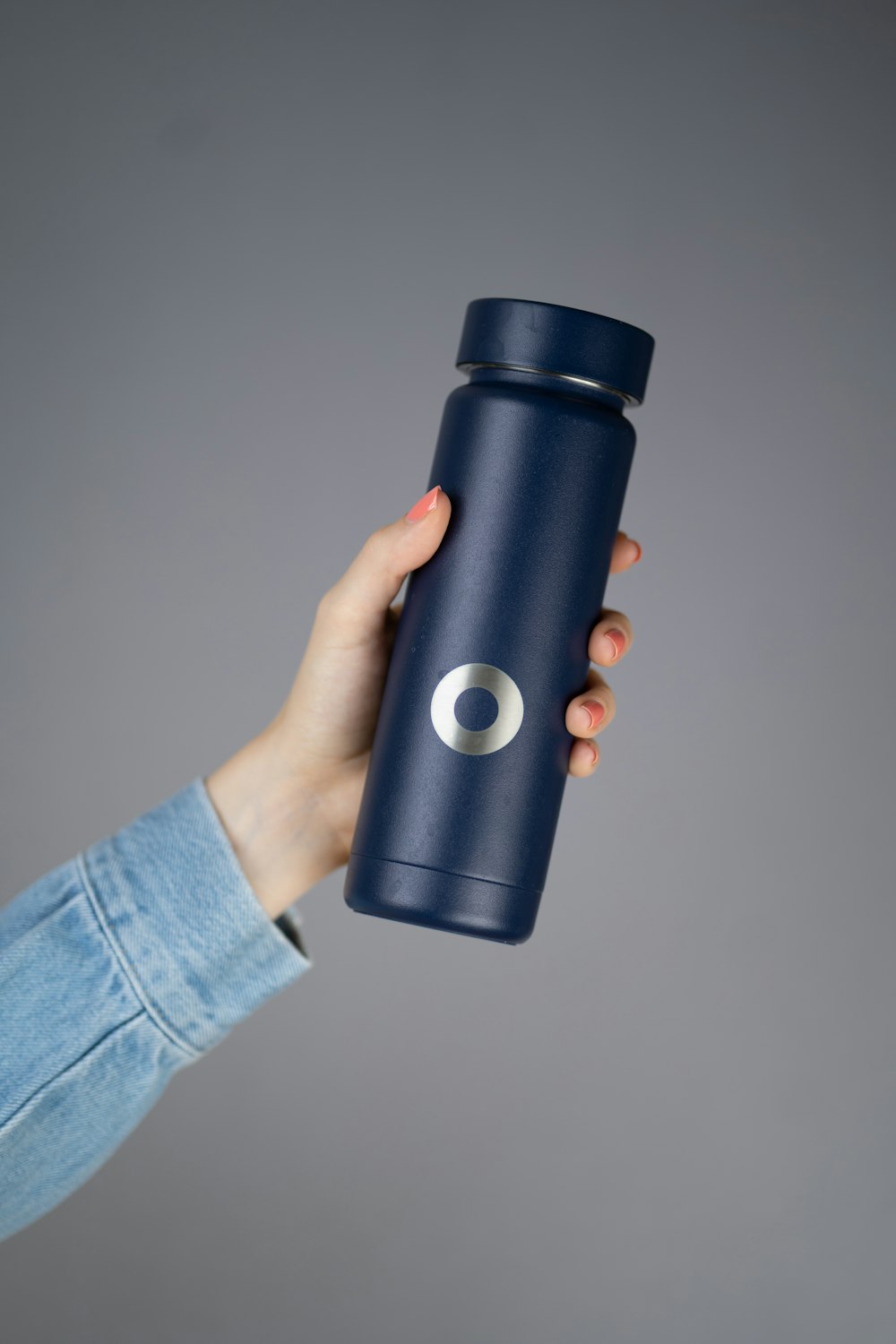 a person holding a blue insulated cup in their hand