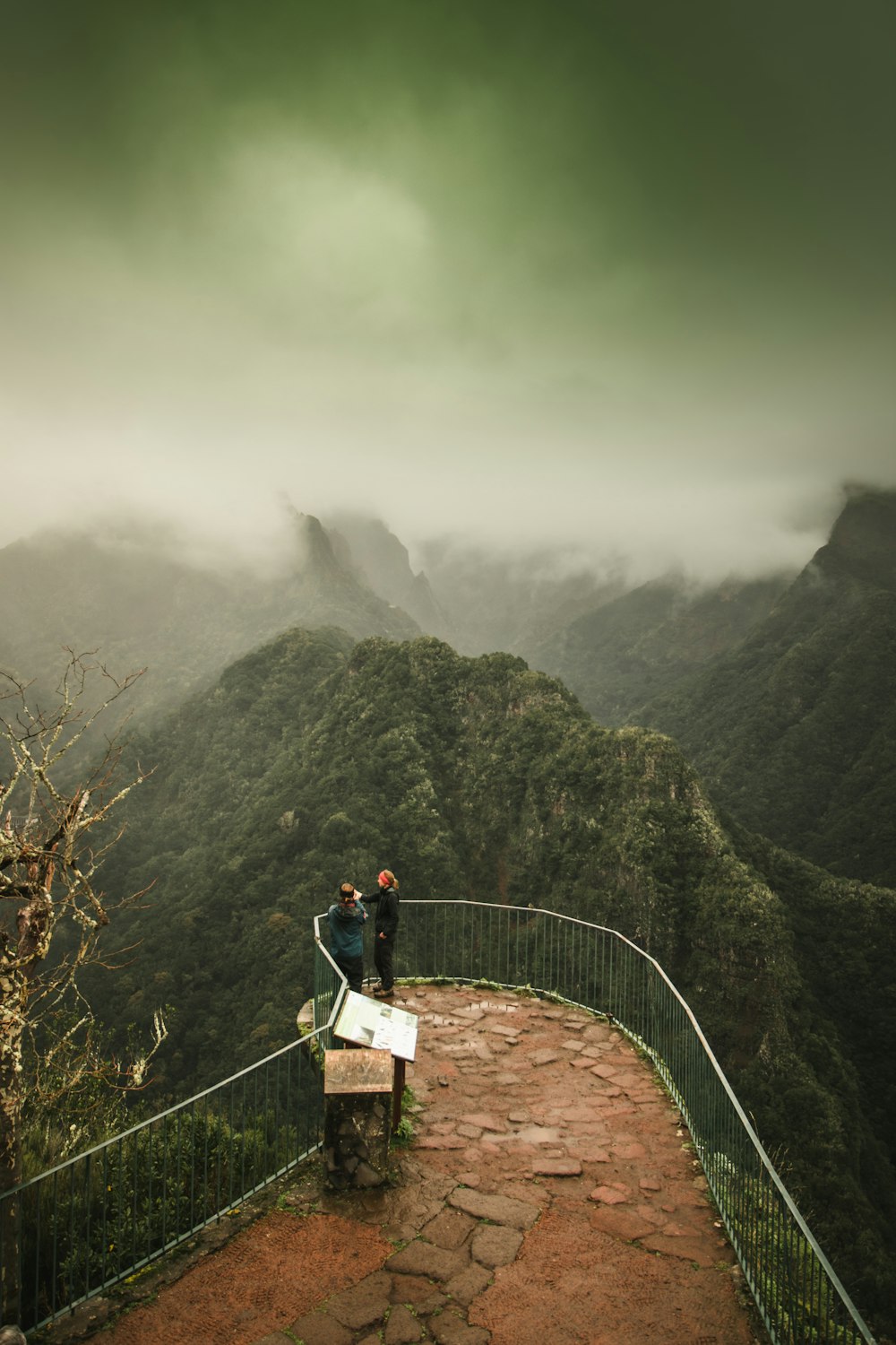 Un par de personas de pie en la cima de una montaña