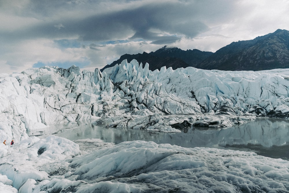 a group of people standing on top of a glacier