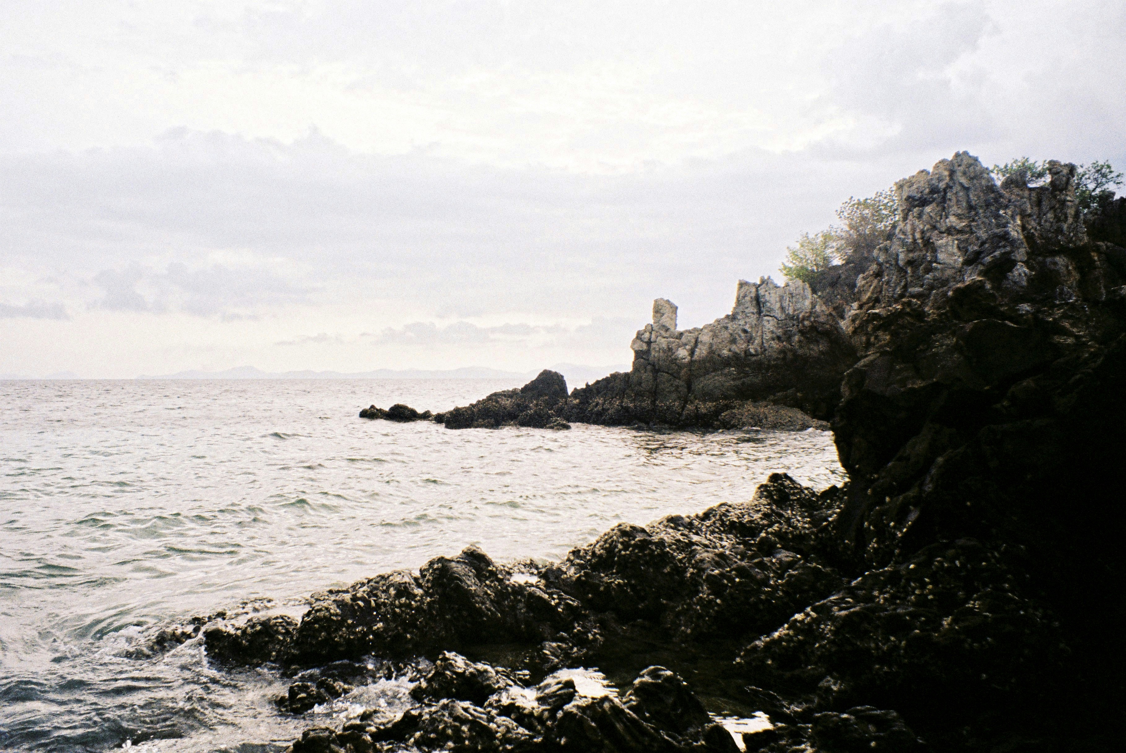 a large body of water sitting next to a rocky shore