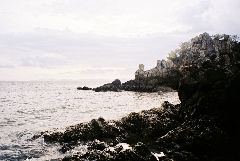 a large body of water sitting next to a rocky shore