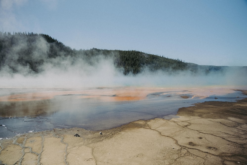 a body of water with steam rising from it