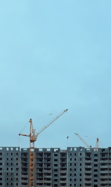a large building under construction with cranes on top of it