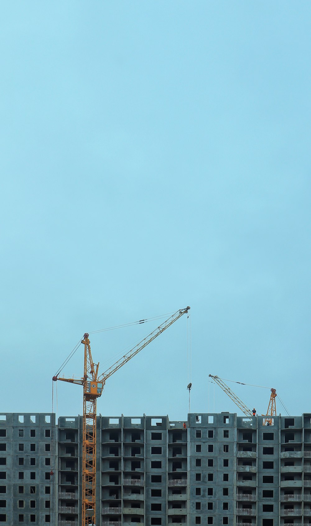 a large building under construction with cranes on top of it