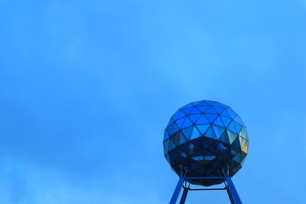 a blue water tower with a blue sky in the background