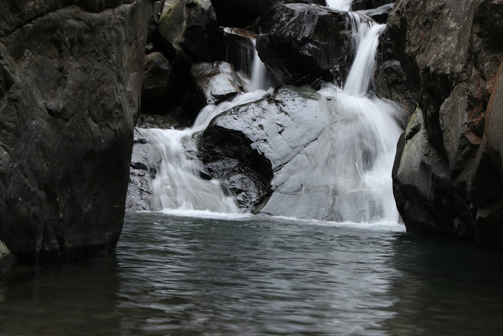 a small waterfall in the middle of some rocks