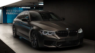 A sleek BMW car being serviced in a modern garage with tools and technicians.