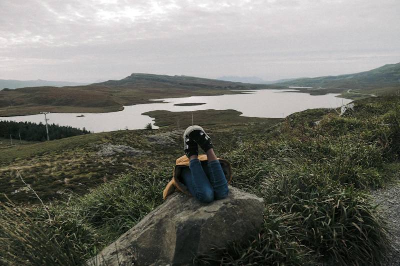 Przystojny podróżnik odpoczywający nad jeziorem