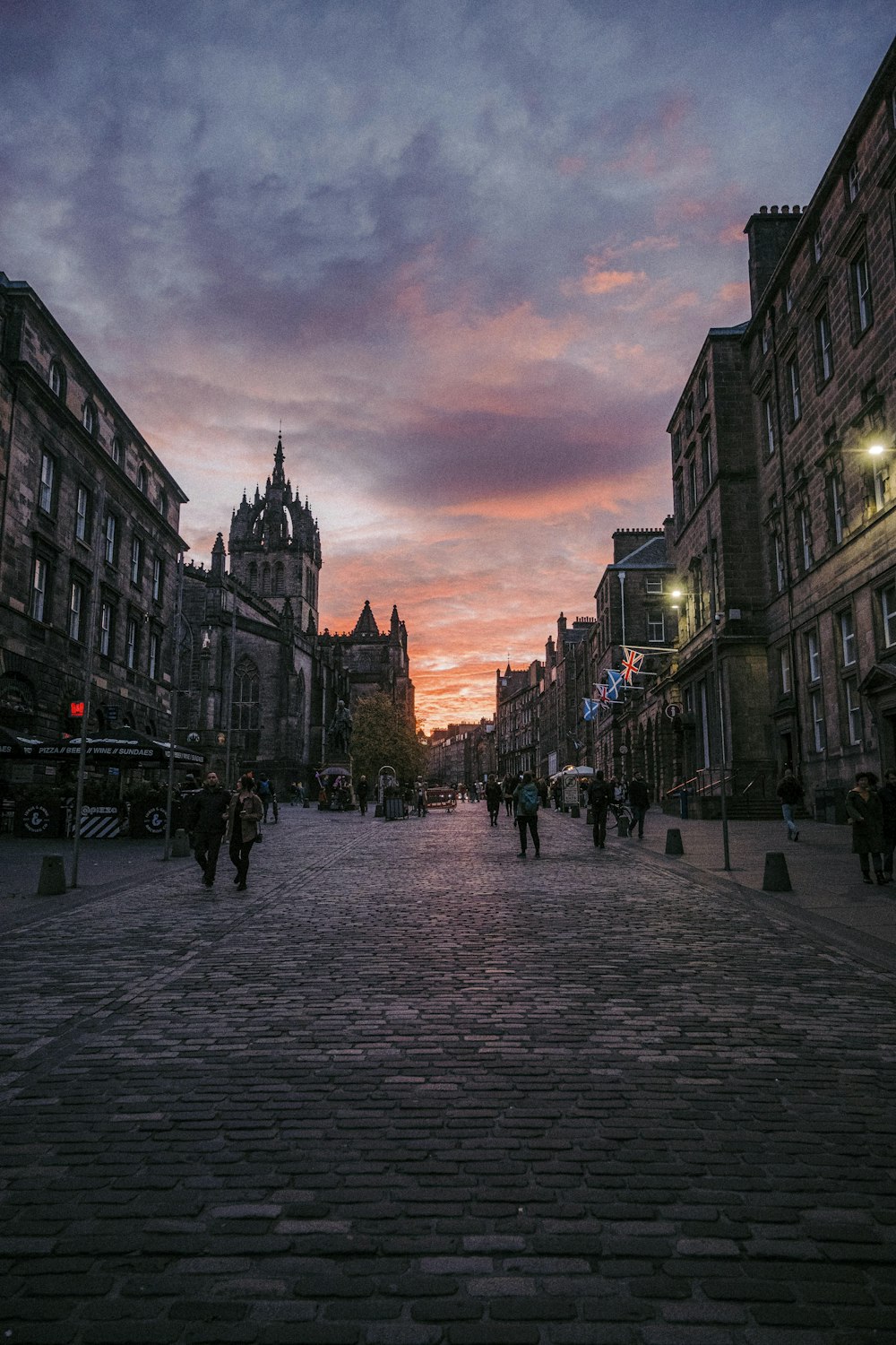 a cobblestone street with a clock tower in the background