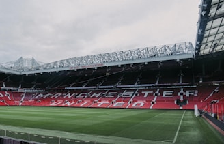 a stadium with a green field and red seats