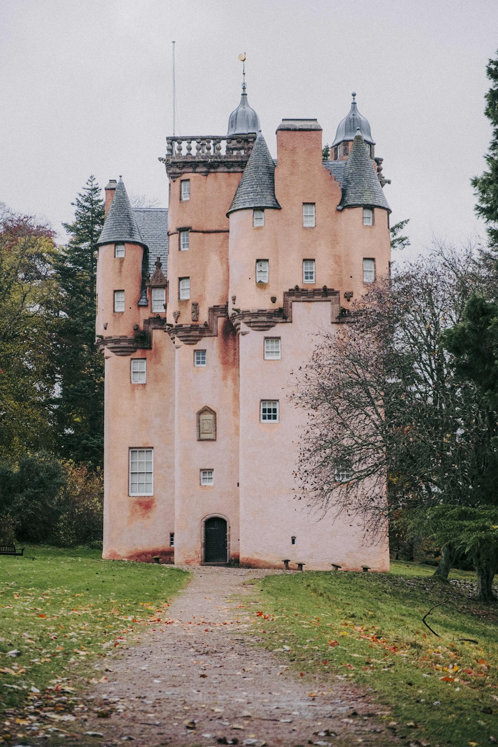 a large pink castle with a walkway leading to it