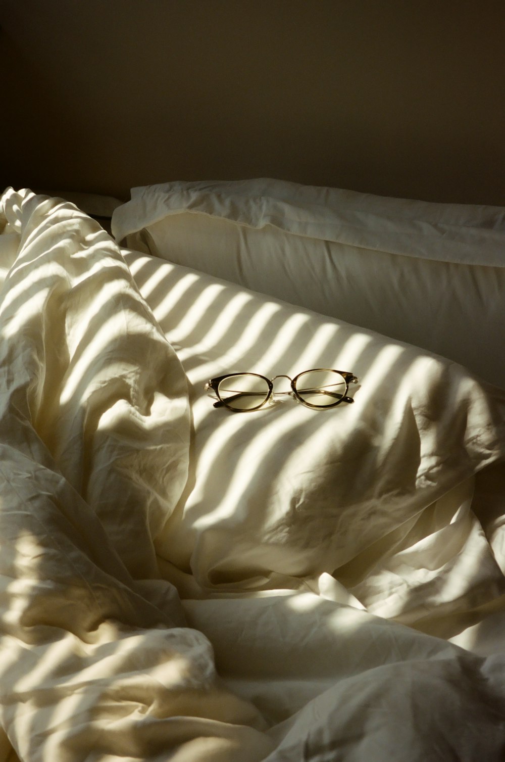 a pair of glasses sitting on top of a bed