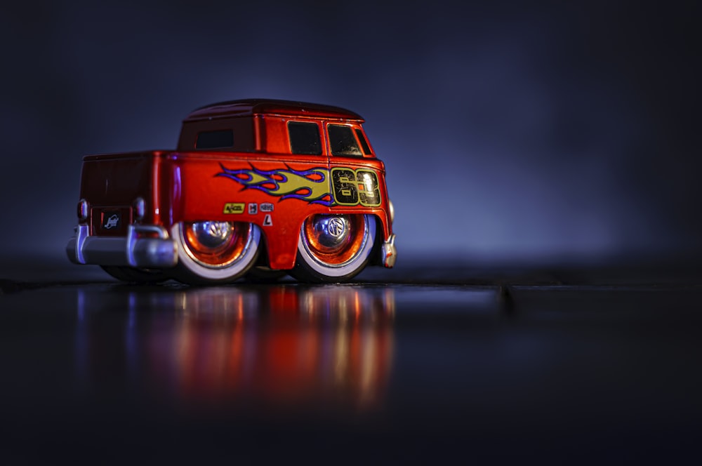 um caminhão de brinquedo vermelho com chamas pintadas sobre ele