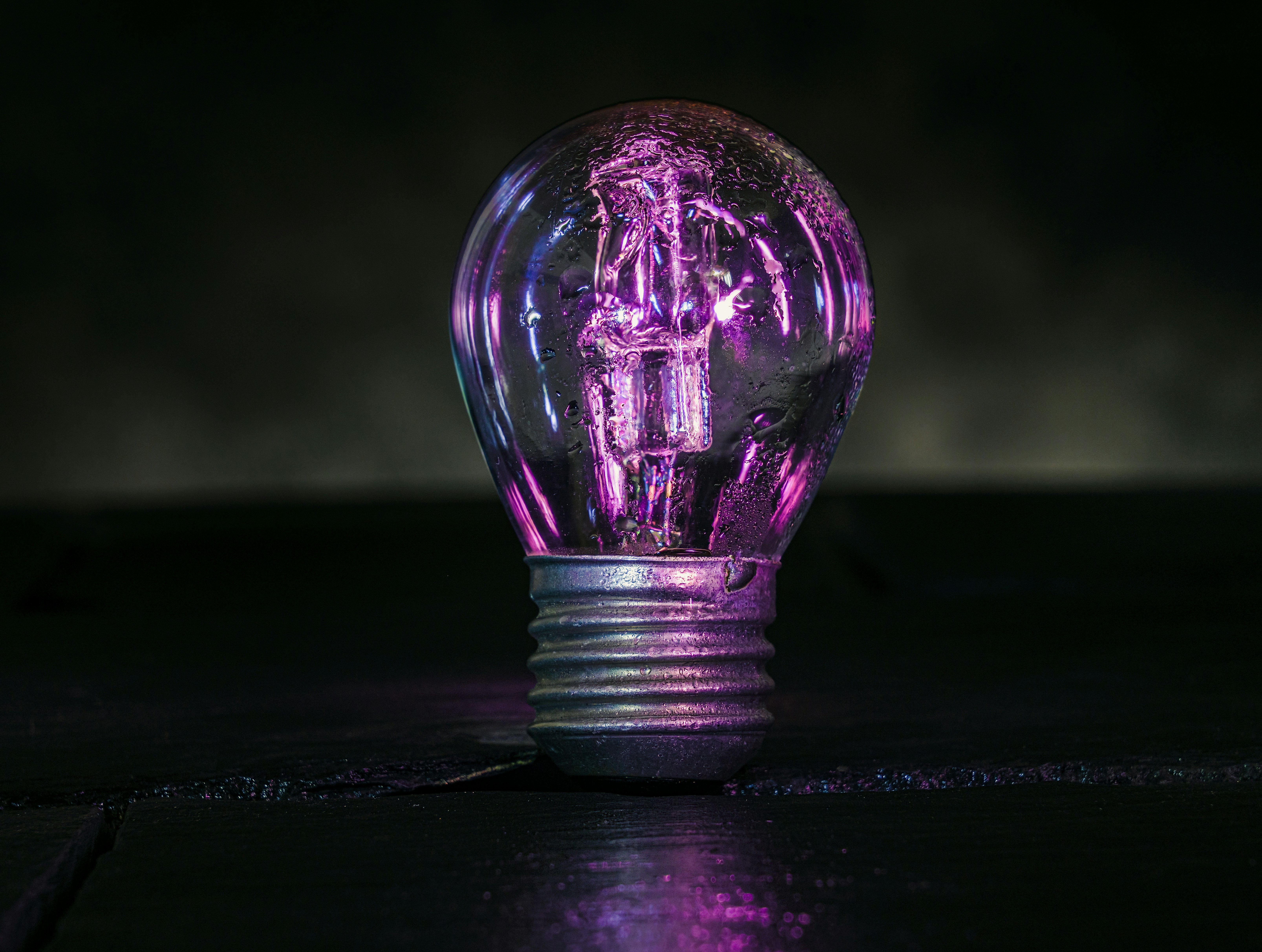 Purple light bulb on table for innovation spotlight