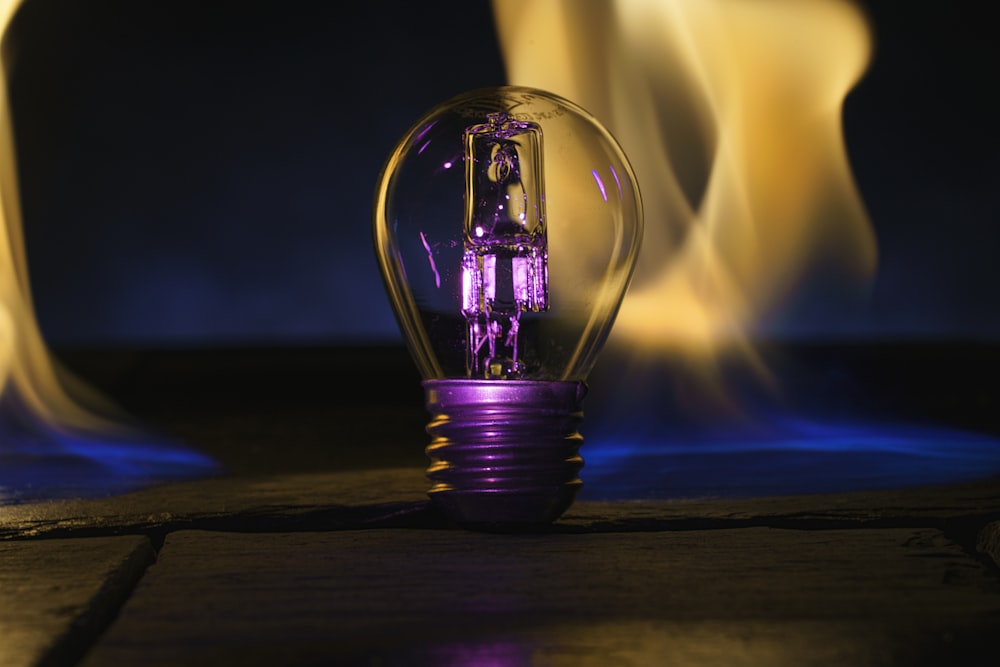 a purple light bulb sitting on top of a wooden table
