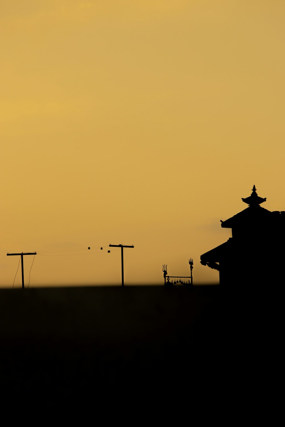 a silhouette of a building with a sky in the background