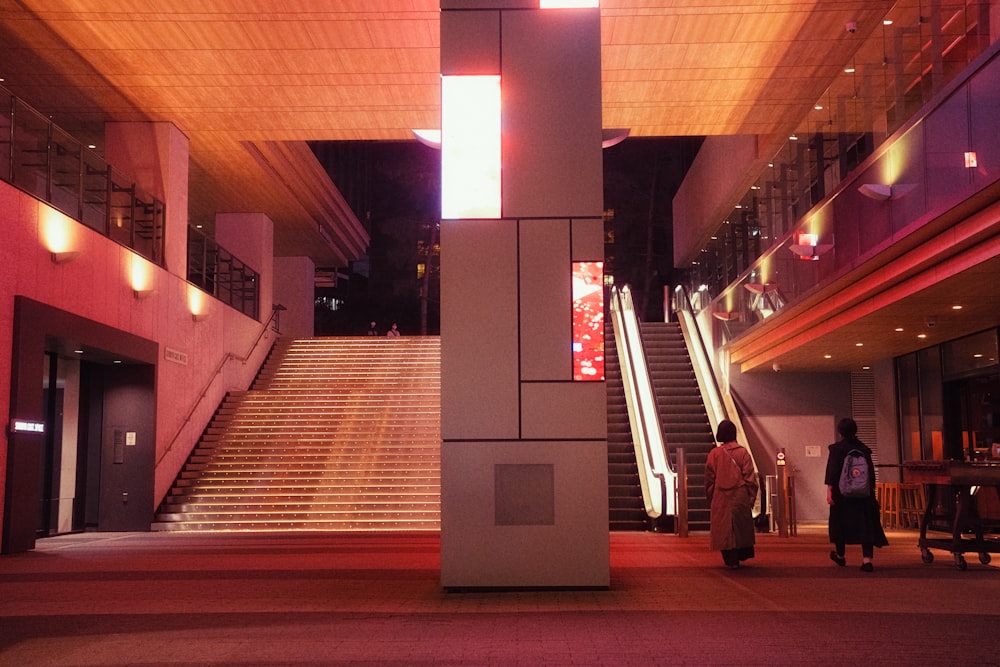 a couple of people that are standing in front of some stairs