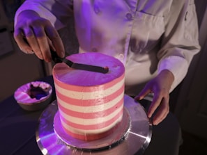 a person cutting a cake with a knife
