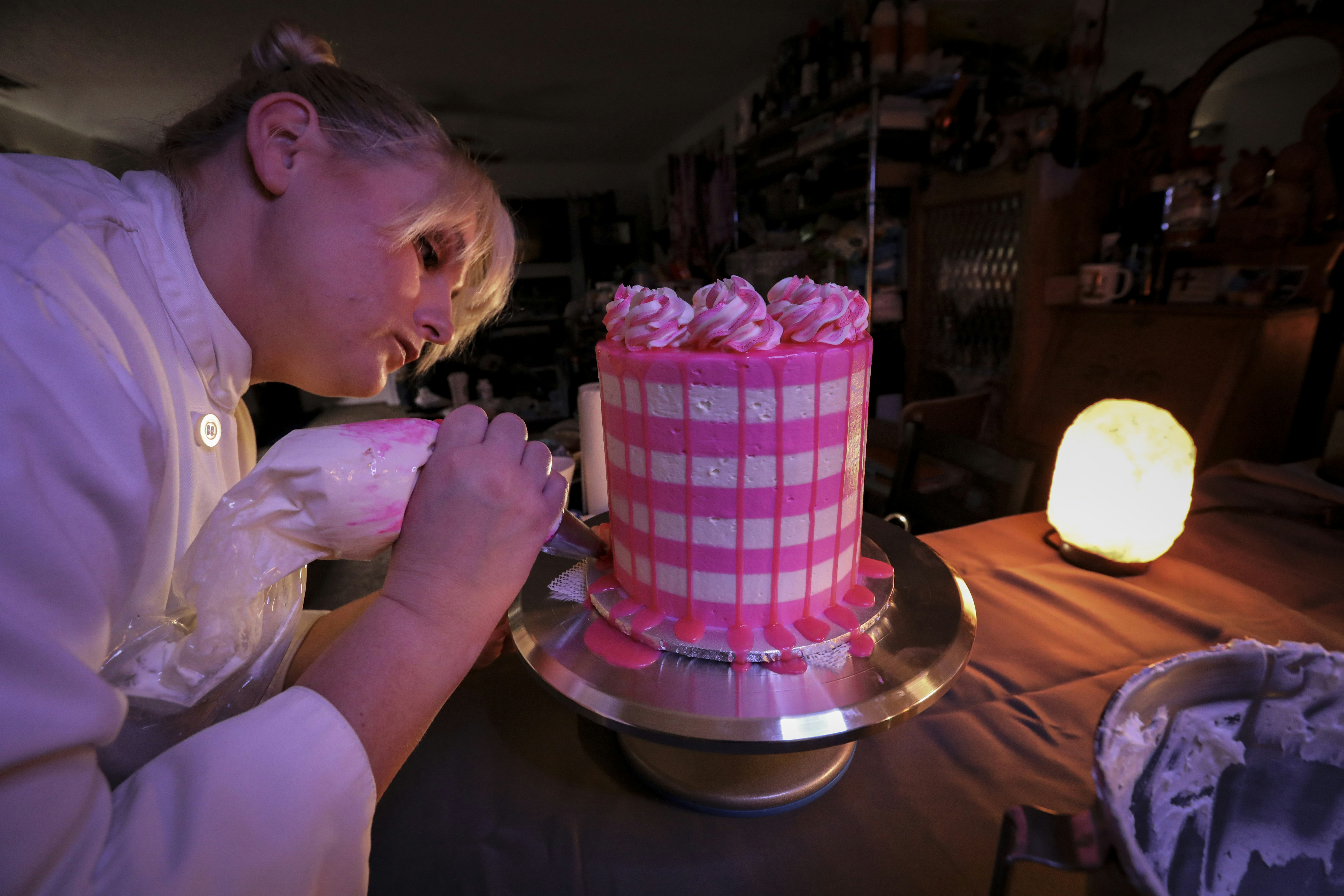 a woman in a white shirt and a pink and white cake