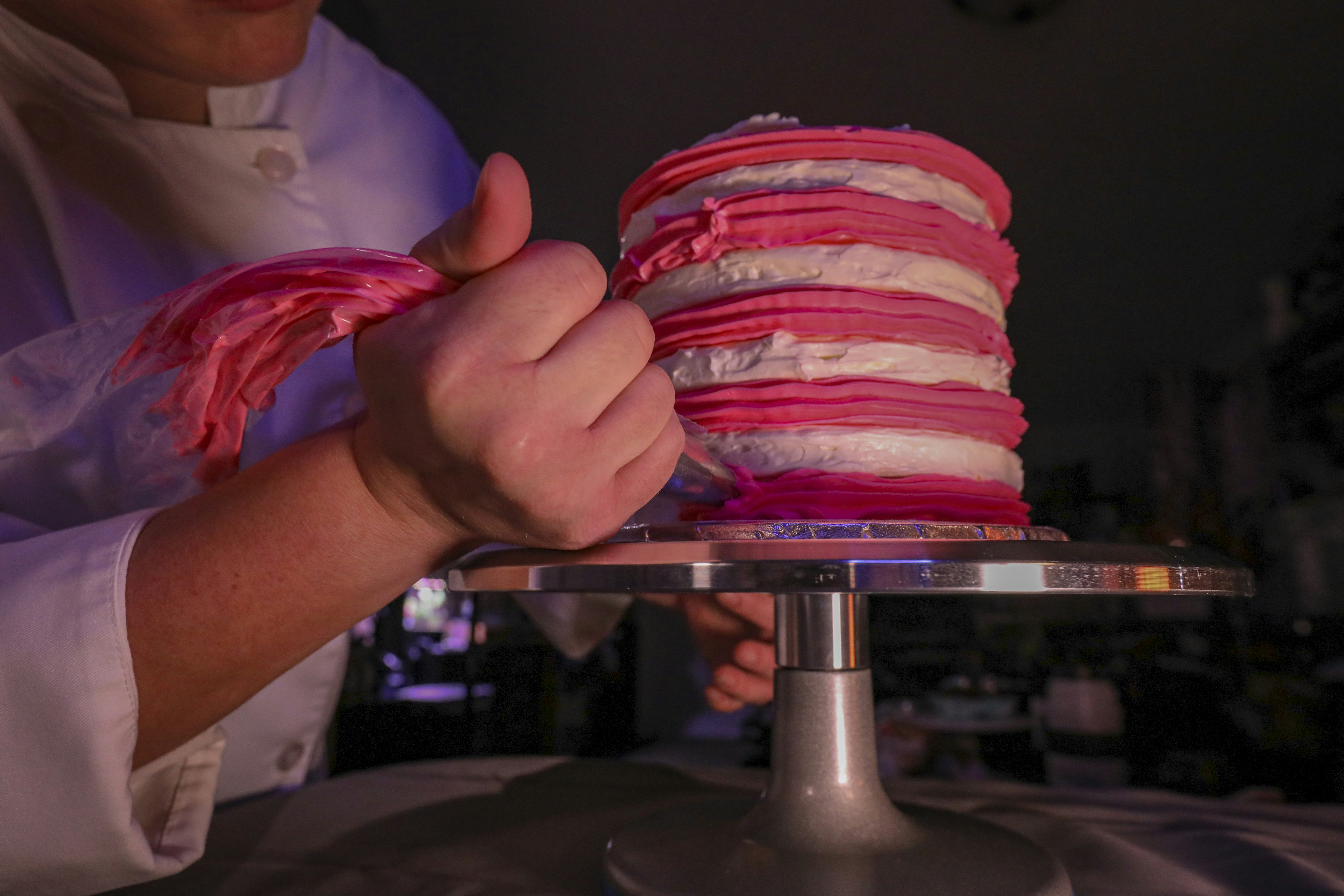 Cake artist piping floral cream details