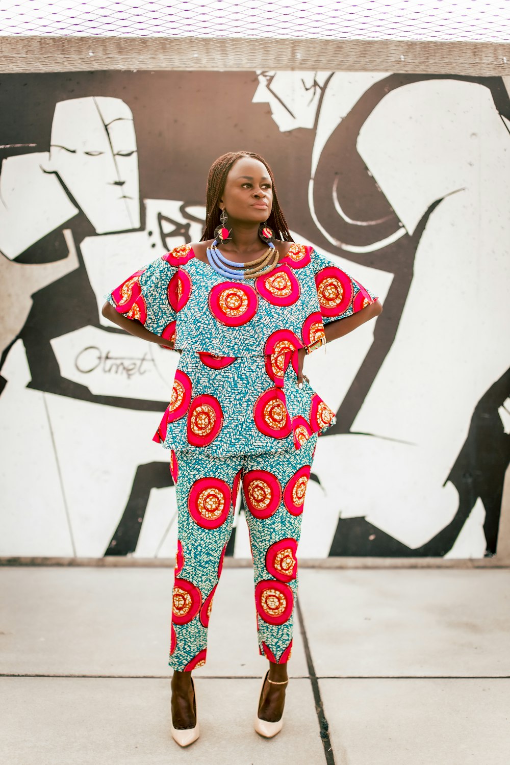 a woman standing in front of a graffiti wall