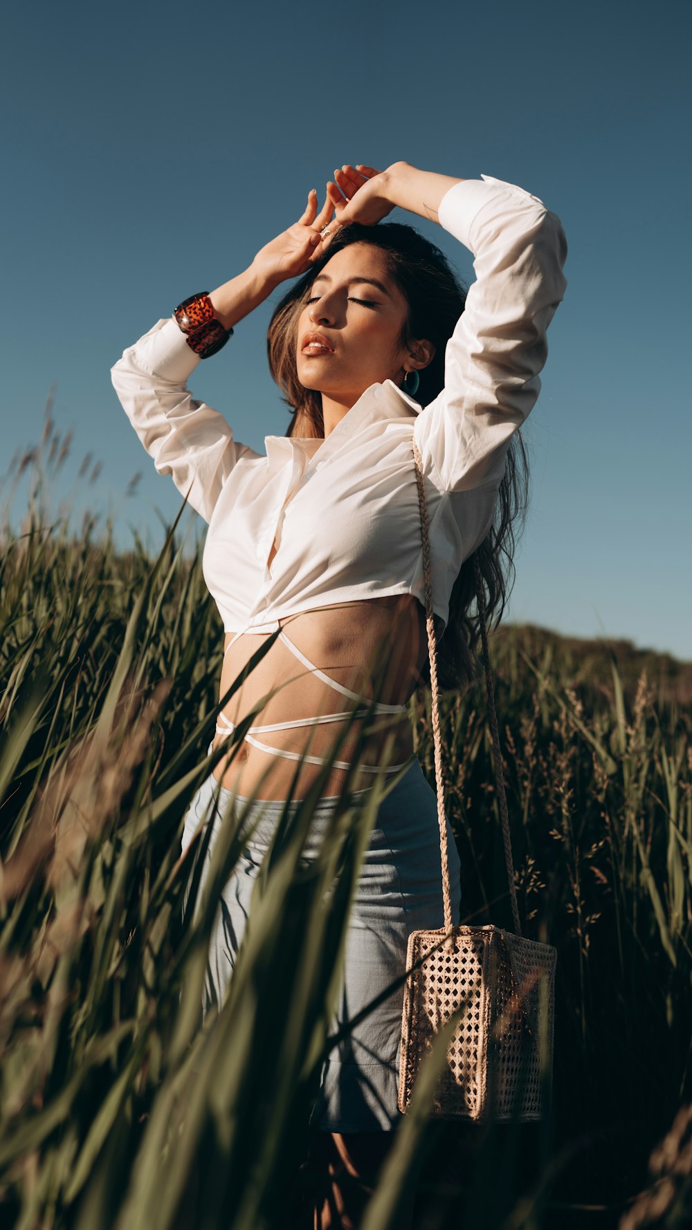 a woman standing in a field of tall grass