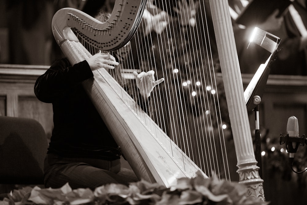 a woman playing a harp in front of a microphone