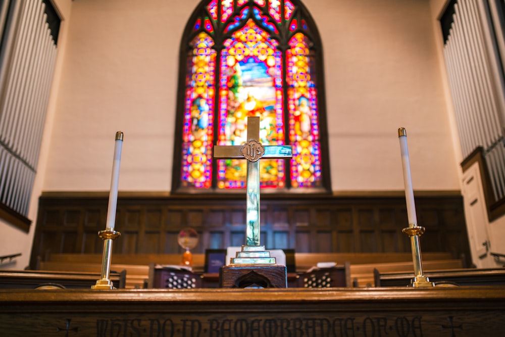 a church with a stained glass window and candles