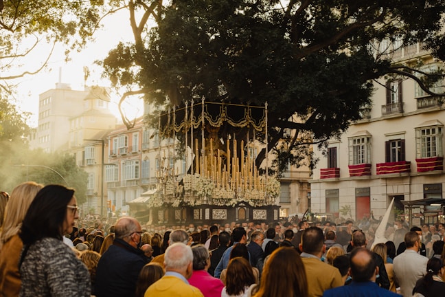 A large crowd gathered outdoors under festive decorations celebrating a spiritual feast.