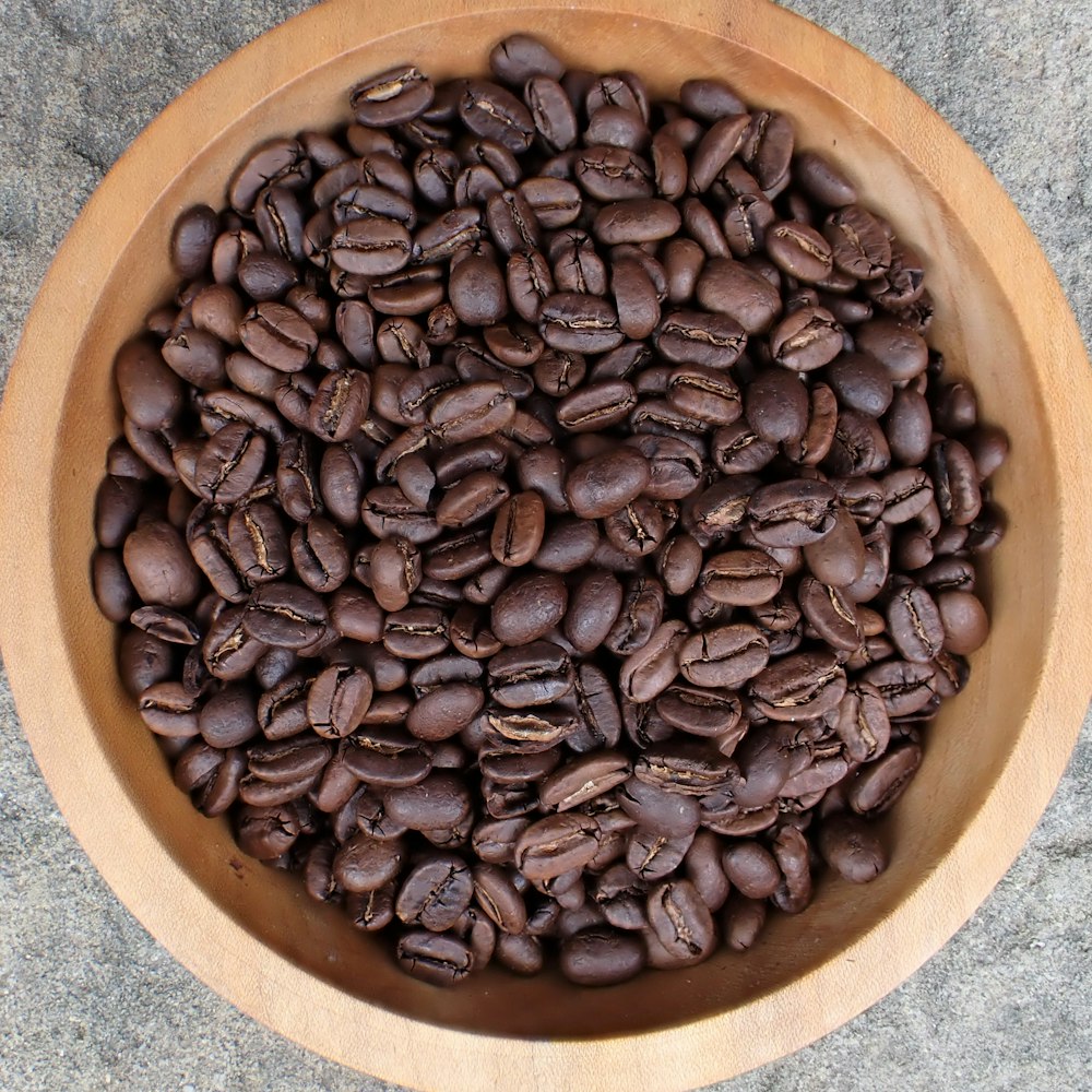 a wooden bowl filled with lots of coffee beans
