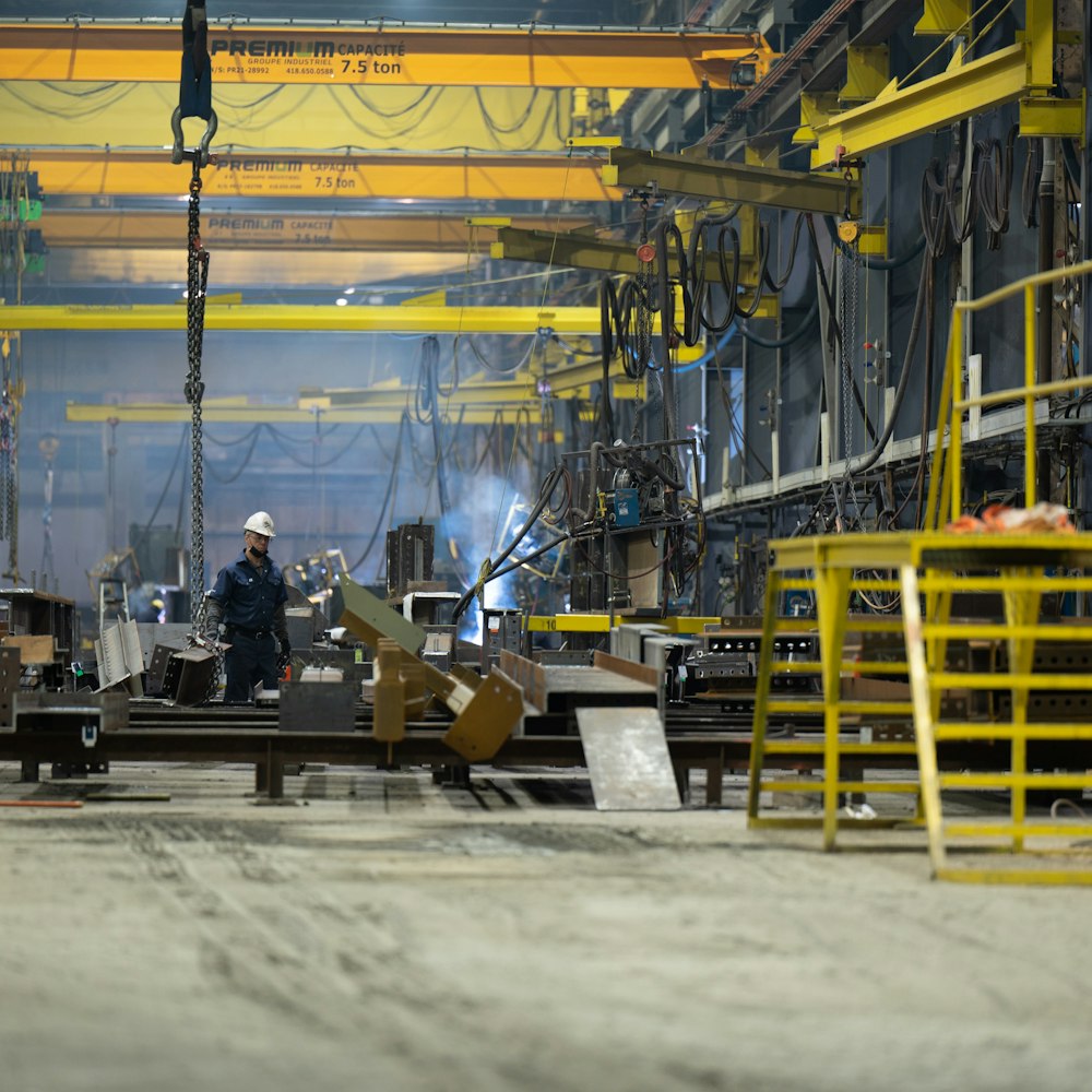 a man standing in front of a machine in a factory