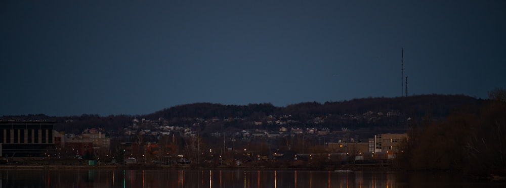 a full moon rising over a city and a lake
