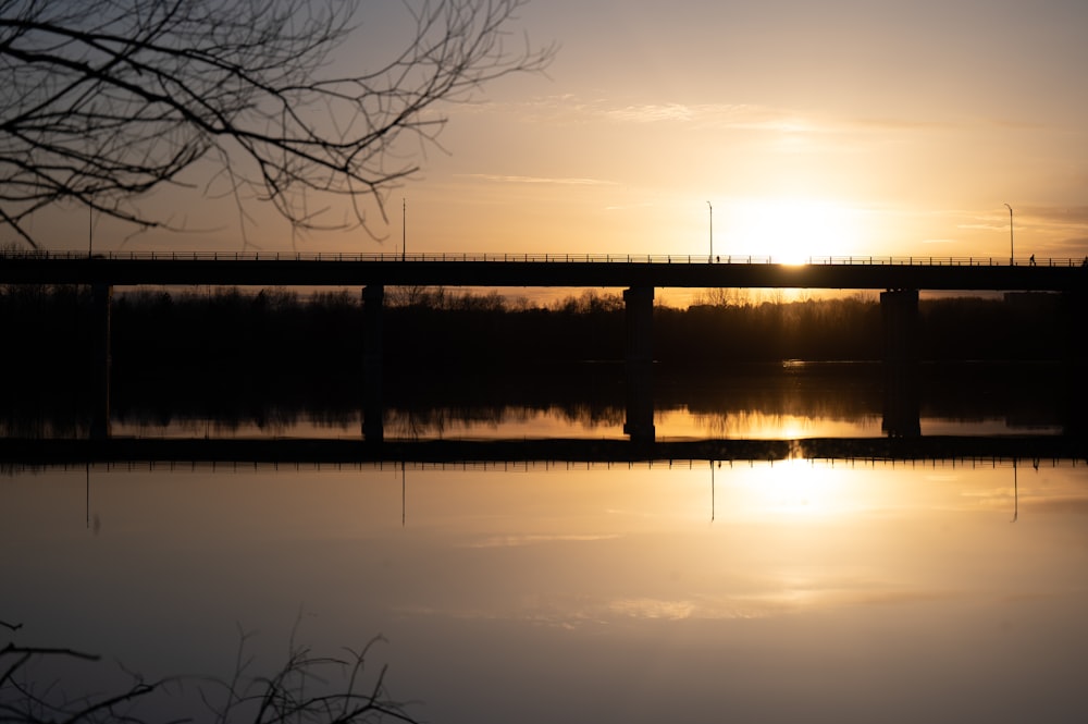 a bridge over a body of water at sunset