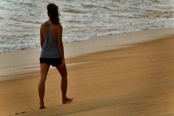 a woman standing on a beach next to the ocean