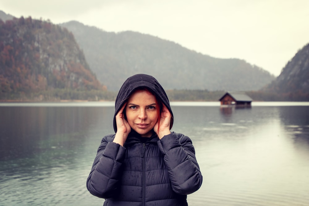 a woman standing in front of a body of water