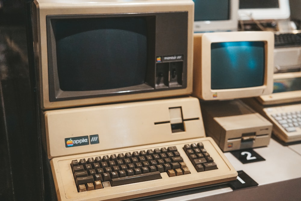 a row of old computers sitting on top of a desk