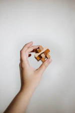 a person holding a wooden block in their hand