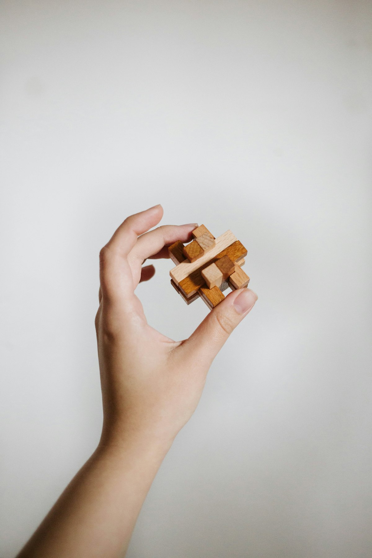 Hands holding a wooden block in skilled craft work, hands-at-work register