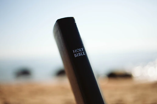 a close up of a black stick with the words holy bible on it