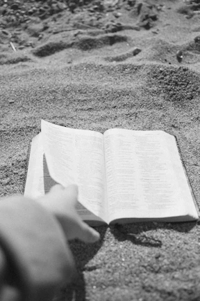 A cinematic photo of a well-worn copy of the memoir resting on a terracotta-colored table with soft sand background.