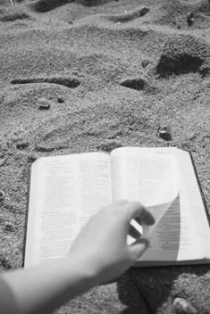 a person is reading a book on the beach
