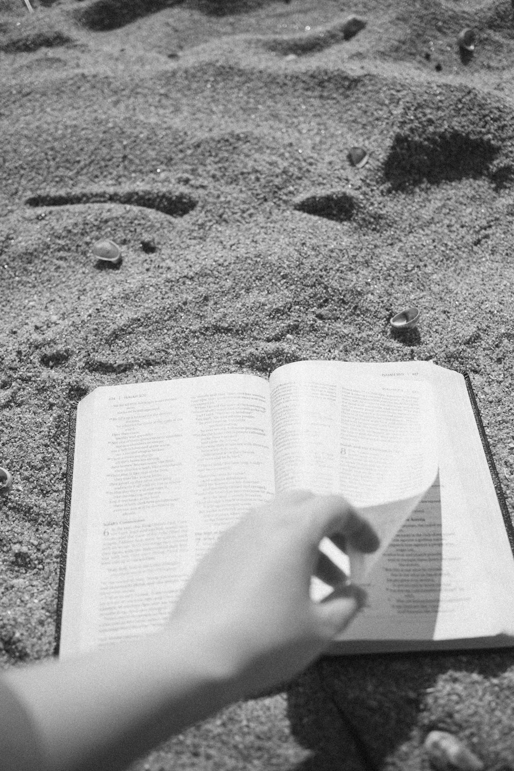 a person is reading a book on the beach