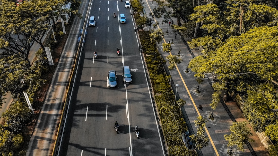 an aerial view of a city street with cars driving on it, Aerial view of major arterial road