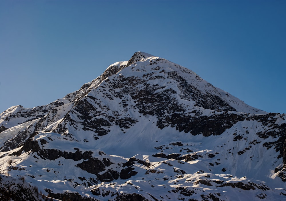 a snow covered mountain with a blue sky in the background