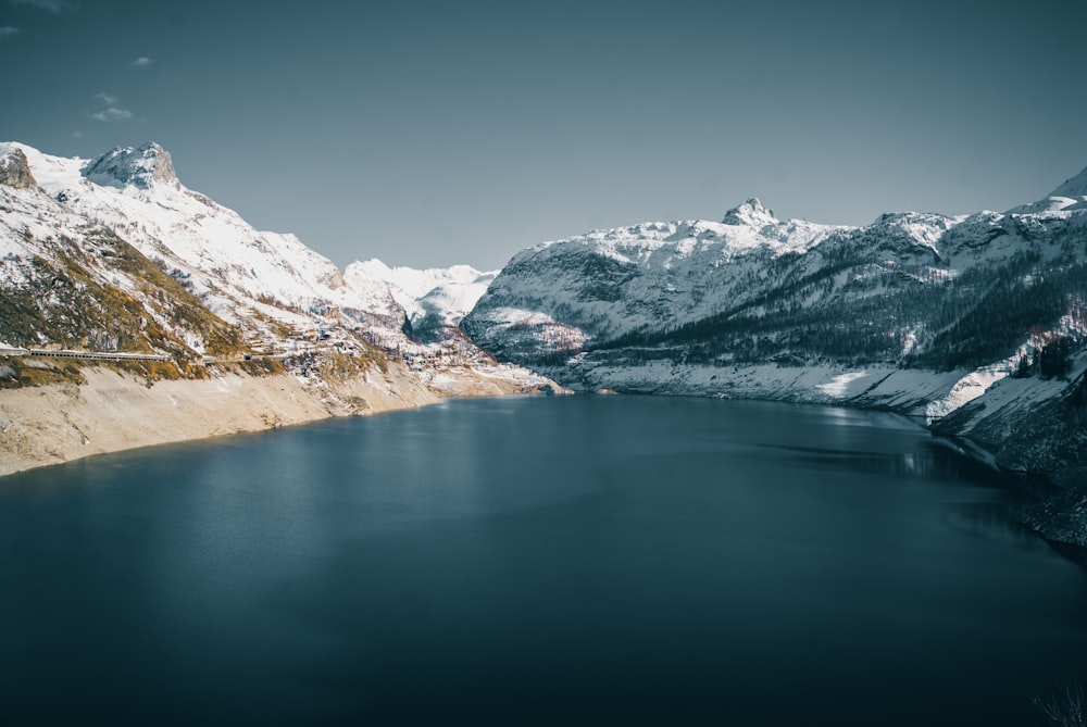 a large body of water surrounded by snow covered mountains