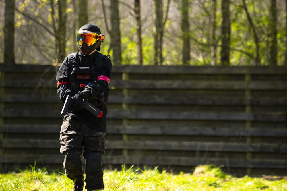 a person wearing a helmet and goggles standing in the grass